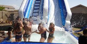 inflatable water slide and kids playing in pool